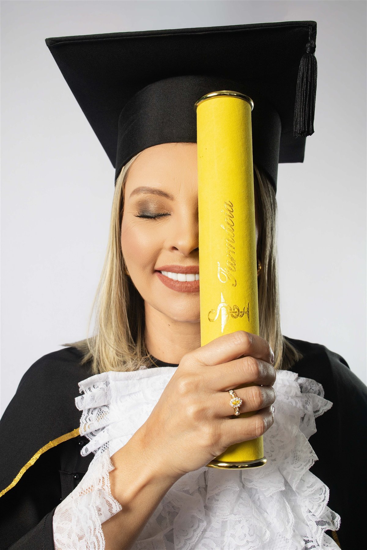 Retrato de Eliana com o canudo amarelo de formatura