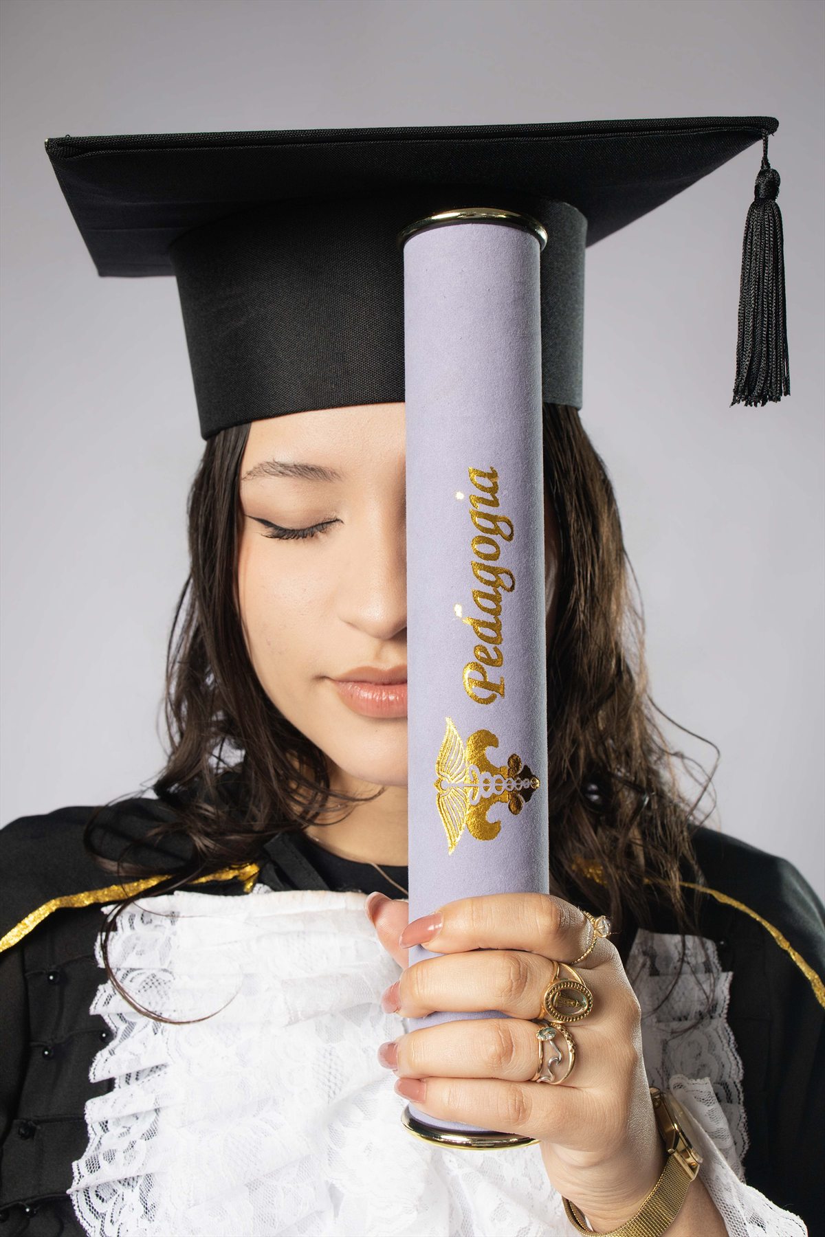 Detalhe de formanda de Pedagogia com o diploma