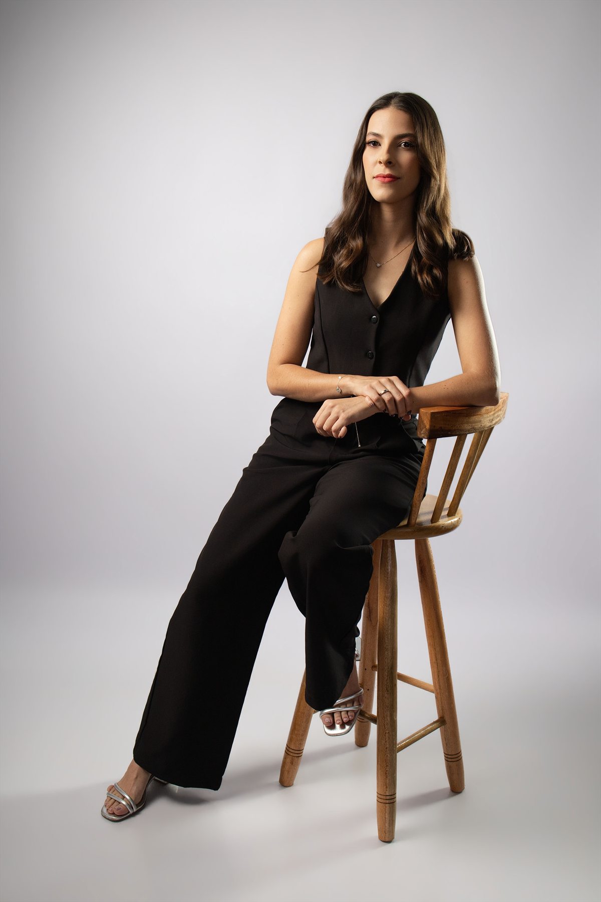 Retrato social de formanda sentada em banco de madeira