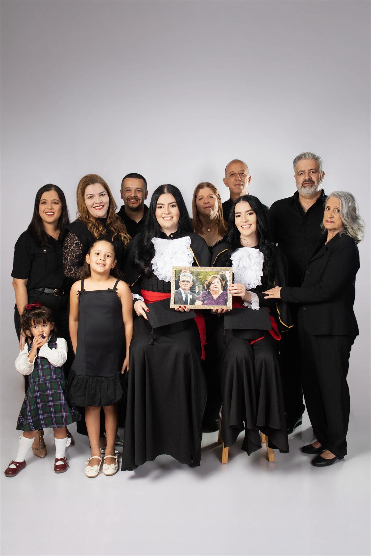 Retrato de duas formandas reunidas com toda a família