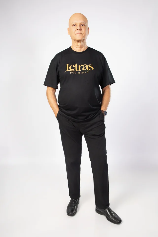 Carlos usando a camisa de Letras da PUC Minas no ensaio de formatura em Belo Horizonte.