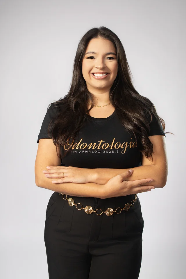 Ysabella de braços cruzados com a camisa personalizada de Odontologia no ensaio de formatura em Belo Horizonte