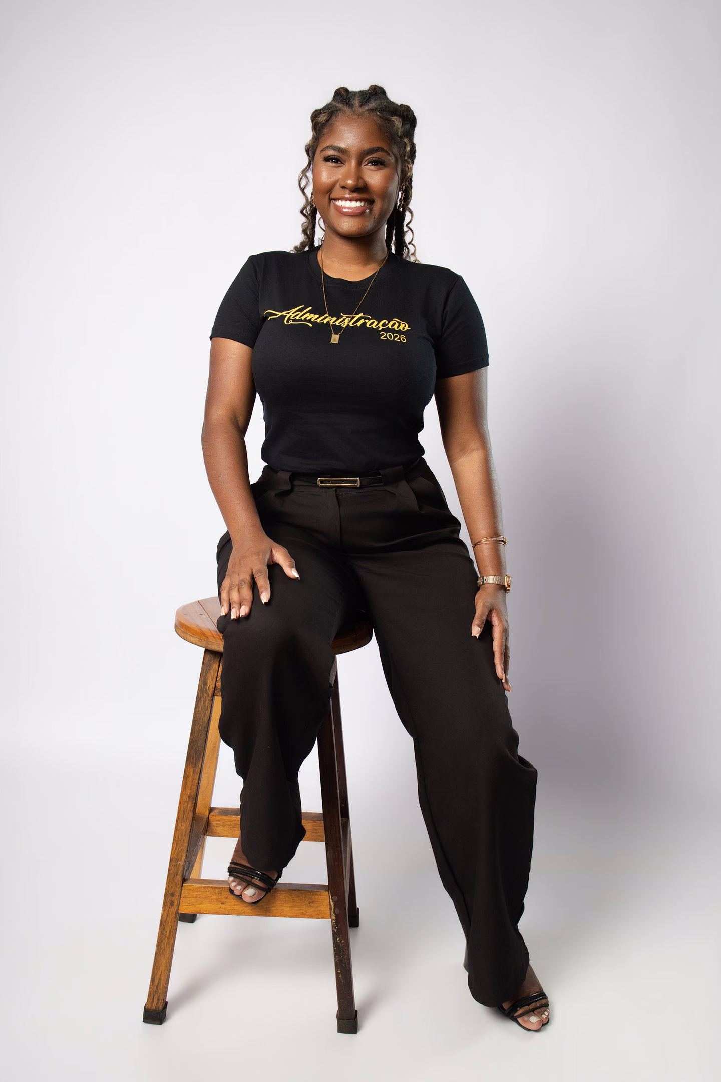 Anna Luiza com camisa personalizada de Administração ao lado de uma banqueta no ensaio de formatura em Belo Horizonte