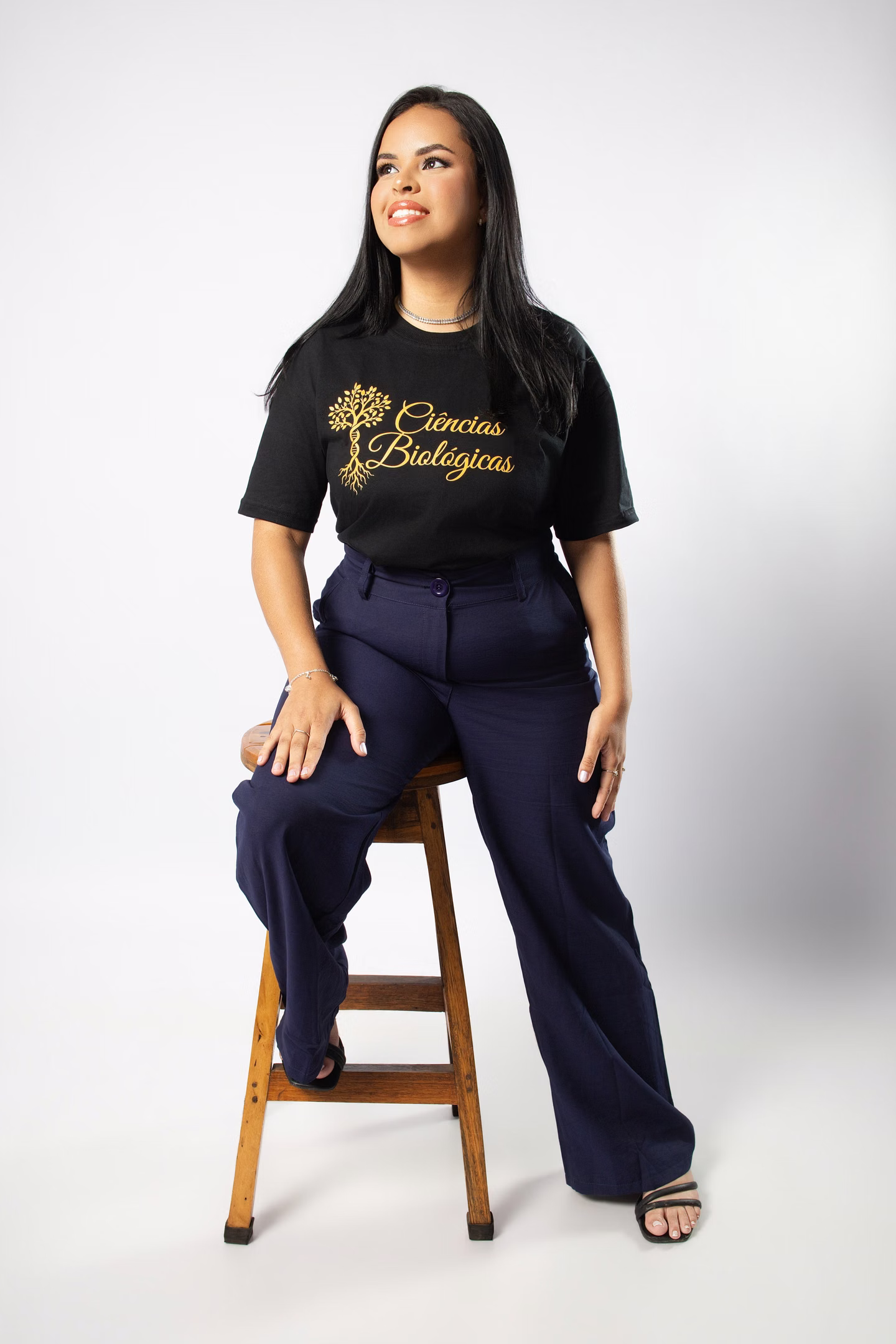 Jully com a camisa do curso, sentada em uma banqueta no ensaio de formatura em Belo Horizonte