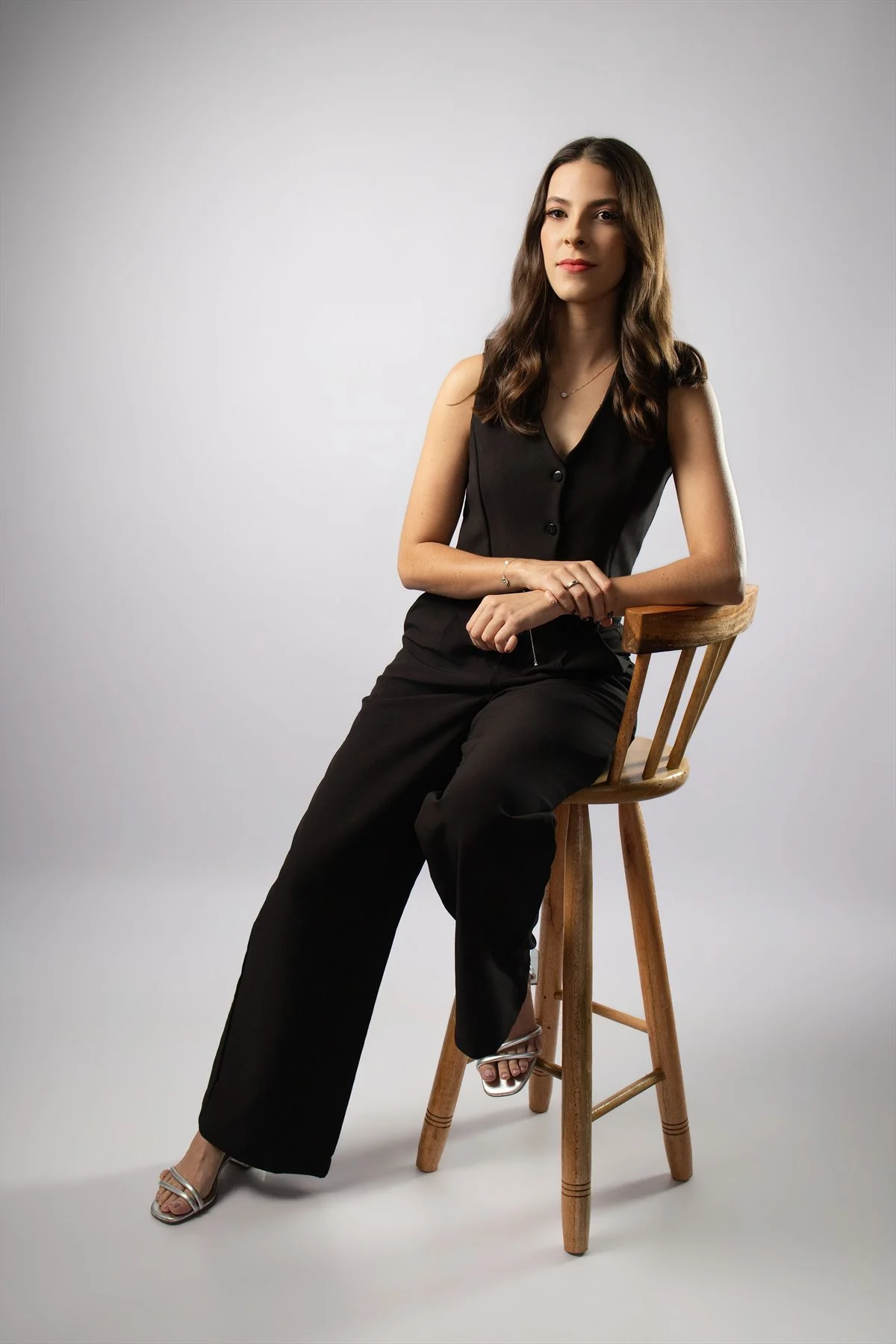 Retrato social de formanda sentada em banco de madeira
